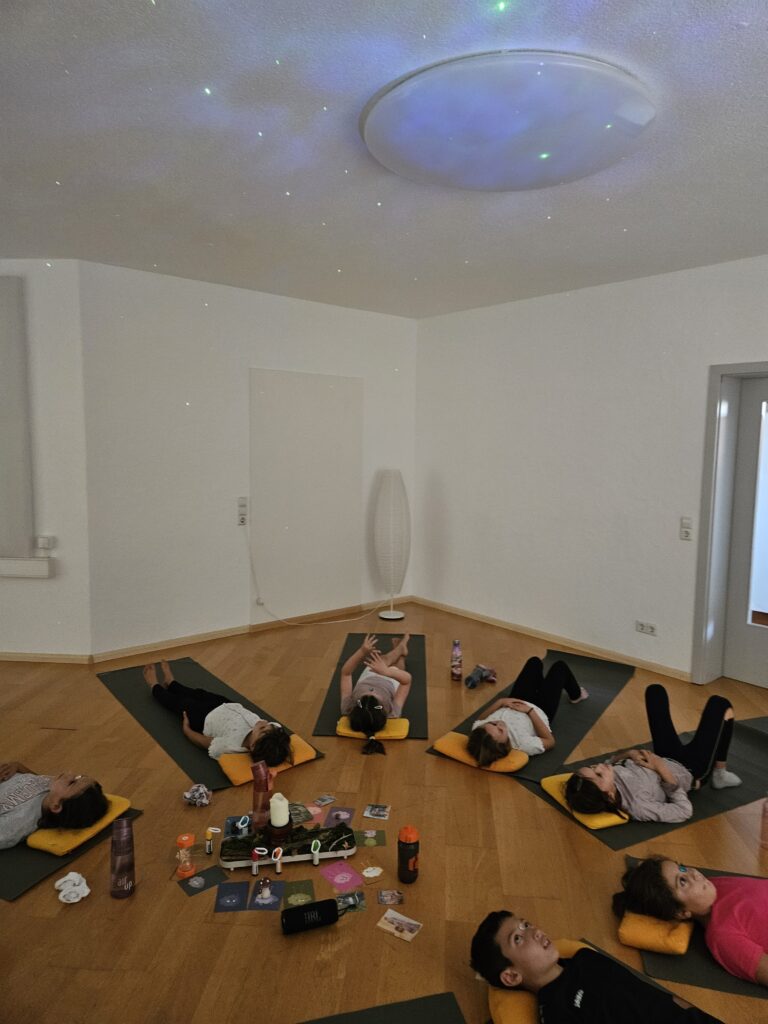 Entspannung beim Kinderyoga in Ebringen unter einem Sternenhimmel an der Decke