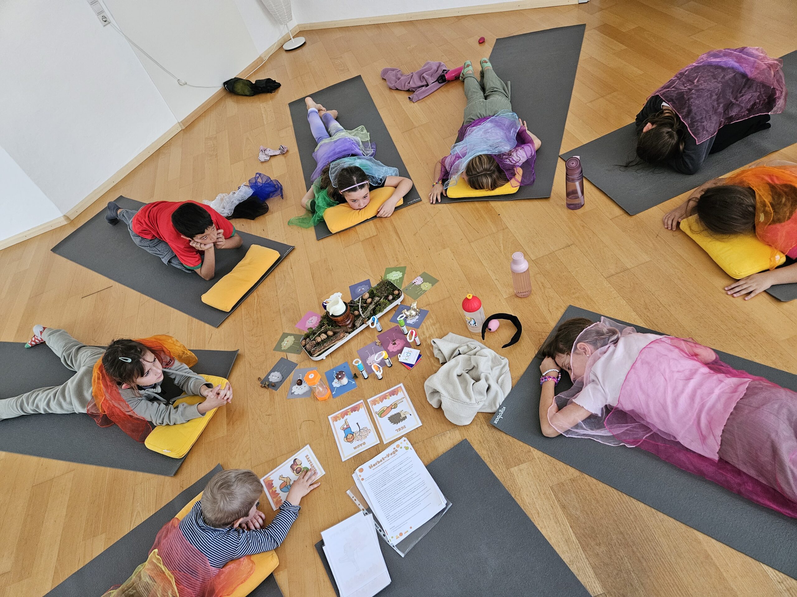 Kinderyoga in Ebringen bei Freiburg: Kinder liegen auf ihren Matten im Kreis um eine Yoga-Geschichte